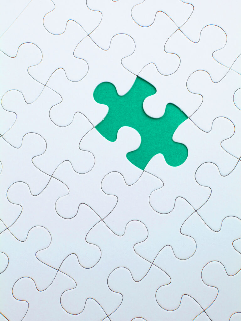 Grünes Puzzleteil unter weißen Puzzleteilen